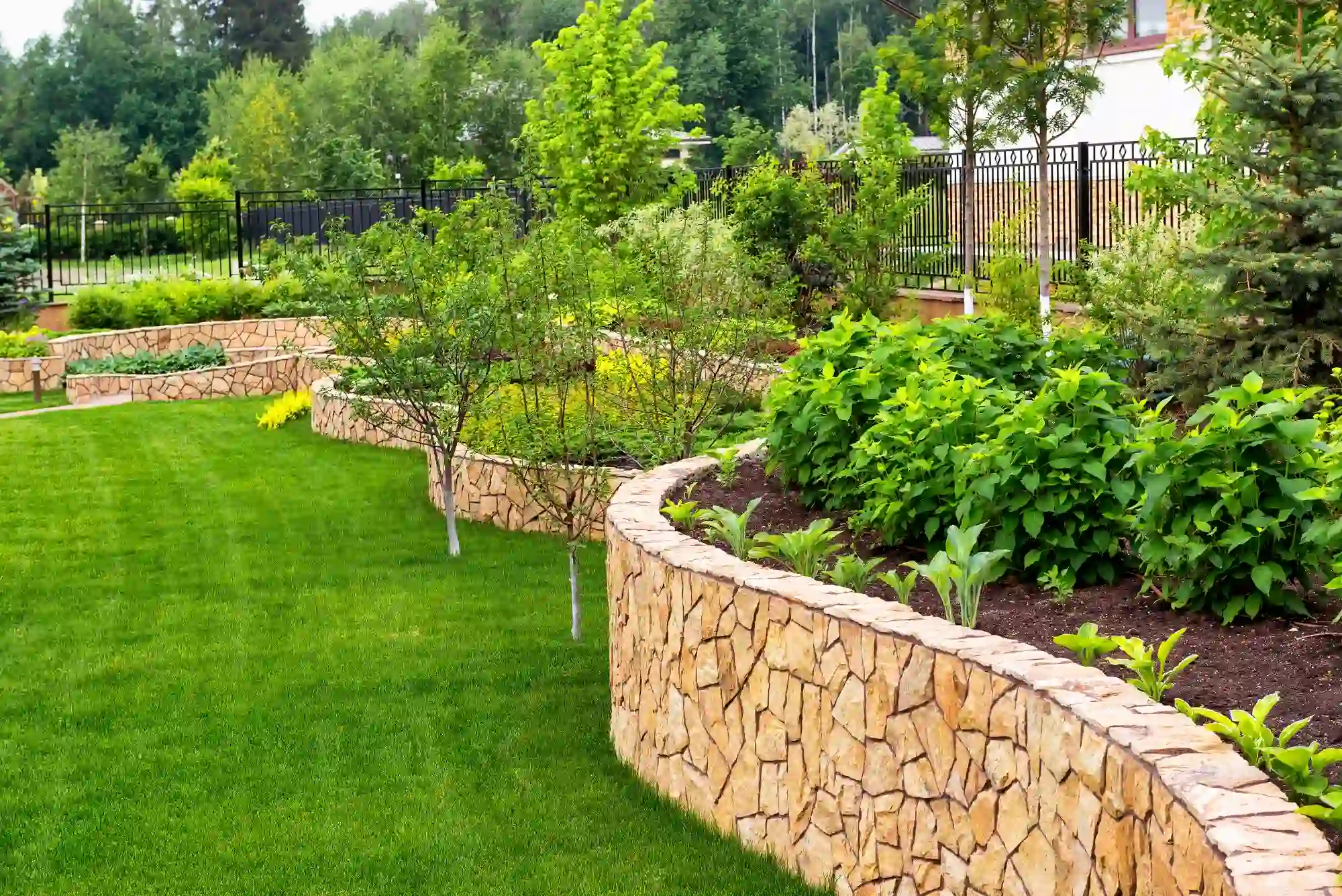 Stone retaining walls provide structural support for sloped terrain areas